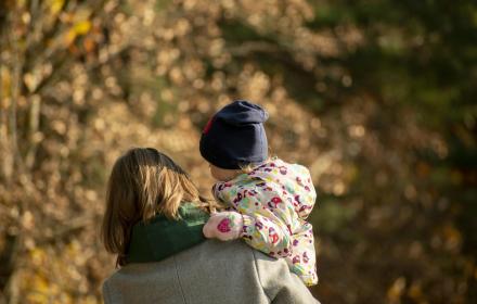 mamma con bimbo in braccio, di spalle